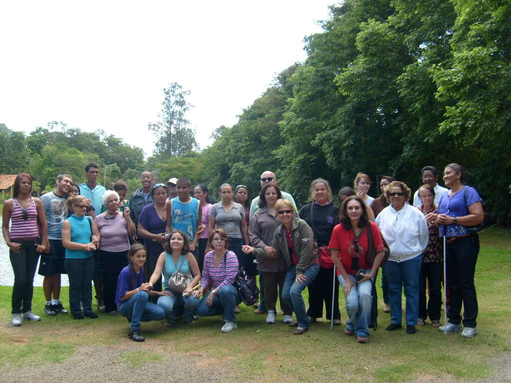 Imagem de 29 pessoas, entre participantes e colaboradores da PARA-D.V.,  num gramado com árvores ao fundo durante um passeio na cidade de Socorro.